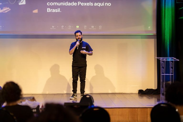 Homem fala ao microfone em um palco durante uma conferência empresarial no Brasil.